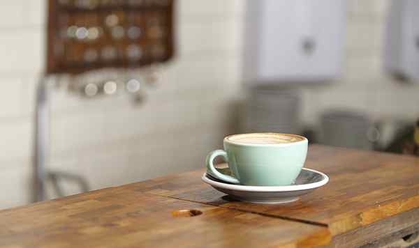 Escritorio ordenado con luz natural y un vaso sobre la mesa